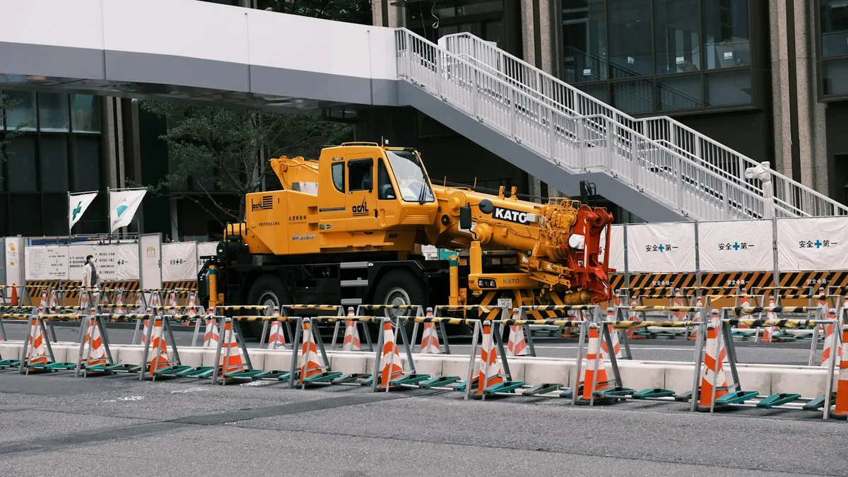 カラーコーンで囲われた工事現場とクレーン車