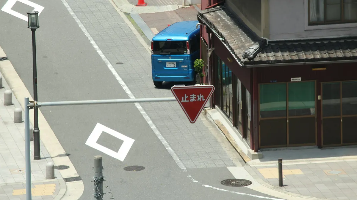 住宅街の交差点に停まるワゴン車